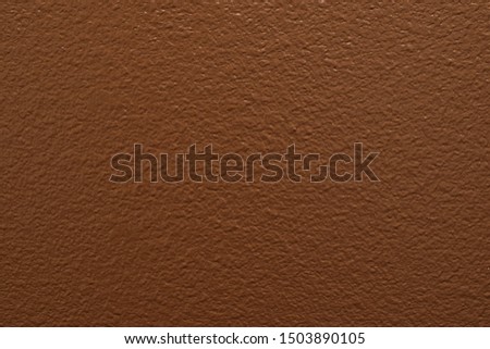 Solid chocolate brown paint color on a section of drywall.