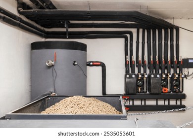 Solid Fuel Boiler with Automatic Pellets Burner and Buffer Tank with Hot Water, Pipes System, Pumps,Manometer in Boiler Room. Modern Eco Heater of Heating System with Wood Bio Pellets.