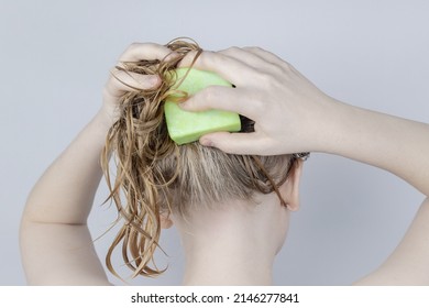 Solid hair shampoo. Close-up of a blonde girl in the bathroom, which lathers her hair with dry shampoo. Lots of foam and peek effect. - Shutterstock ID 2146277841