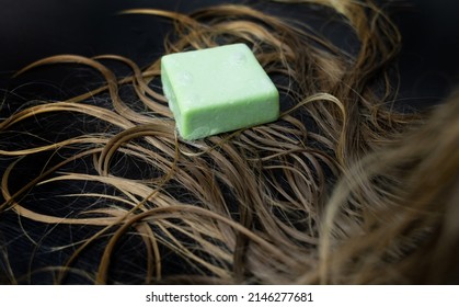 Solid Hair Shampoo. Composition Of Golden Curls, Soap Suds, Solid Shampoo And Comb. The Concept Of Female Care For Long Hair.