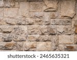 Solid house stone wall of roughly hewn stone closeup as stone background