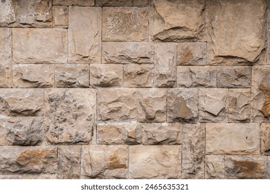 Solid house stone wall of roughly hewn stone closeup as stone background