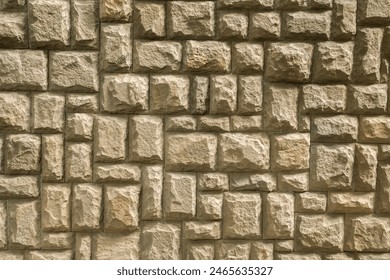 Solid house stone wall of roughly hewn stone closeup as stone background