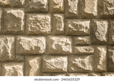 Solid house stone wall of roughly hewn stone closeup as stone background