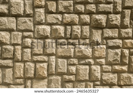 Solid house stone wall of roughly hewn stone closeup as stone background