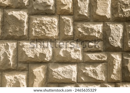 Solid house stone wall of roughly hewn stone closeup as stone background