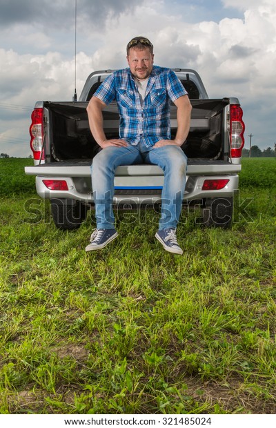 Solid man sitting on car\
trunk