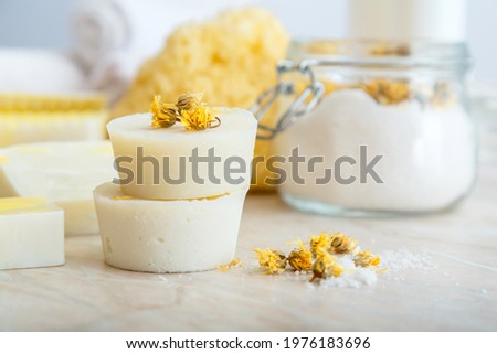 Solid shampoo bar many and handmade soap round bars with herbs dry marigold flowers. Spa bathroom products aroma salt, natural washcloth on marble table. Beauty cosmetics products for relax bodycare.