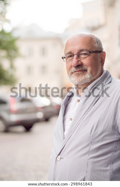 solid smiling man in the city on the background of\
cars and houses
