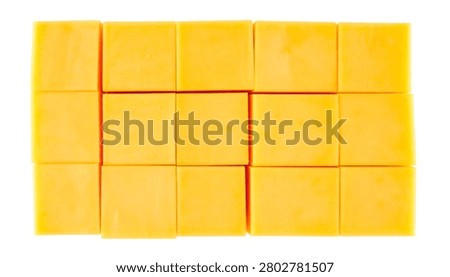 Solid yellow cheddar cheese cut into exact perfect geometric cubes arranged in a precise grid isolated on white.