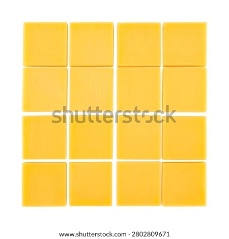 Solid yellow cheddar cheese cut into exact perfect geometric cubes arranged in a precise grid isolated on white.