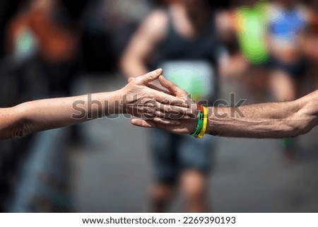 The solidarity handshake in sport. Support during the physical effort of the race of an athlete running the marathon.