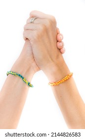 Solidarity Symbol Concept For Ukraine Situation. Close Up View Of Two Hands United With Bracelets Indicating Country Colors (yellow And Blue). Europe Alliance Support For Refugees Of Ukraine War.