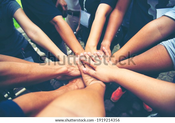 Solidarity unite people hands together community\
teamwork. Hands of spirit team working together outdoor. Unity\
strong handshake with people or agreement of feeling or happy\
diverse education\
action
