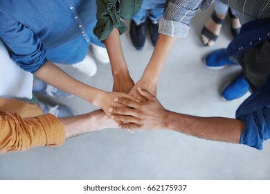 Solidarity and unity conept. Cropped shot of business partners holding their hands together expressing their agreement. True friends keeping their hands together swearing always help each other