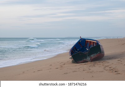 Solitary And Abandoned Immigrant Dinghy Patera Boat At The Atlantic Coast Of South Spain