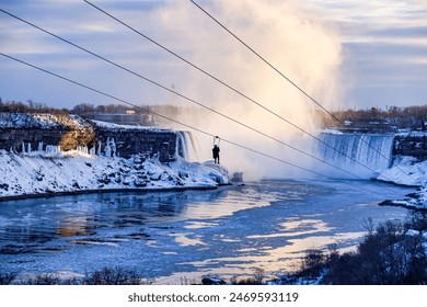 A solitary figure dangles from a zipline over the frozen Niagara Falls, the mist and icy water creating a breathtaking winter landscape. - Powered by Shutterstock