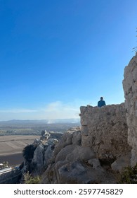 Solitary Figure Overlooking Vast Valley from Ancient Stone Ruins