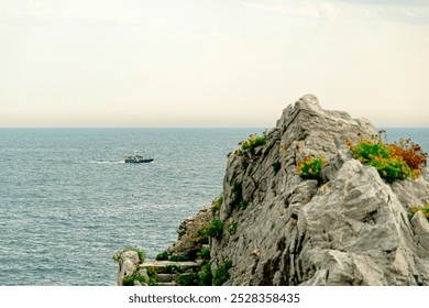 A solitary fishing boat navigates the vast, calm ocean under a pale sky. The minimalistic scene conveys solitude, tranquility, and the endless expanse of the sea. - Powered by Shutterstock