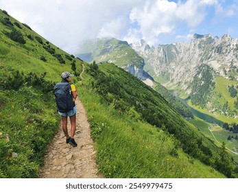 A solitary hiker makes their way along a winding trail, surrounded by breathtaking mountains and vibrant greenery. The sun shines brightly on this perfect day for adventure in Switzerland - Powered by Shutterstock