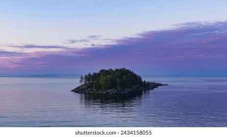  A solitary island basks in the tranquil hues of twilight, with the calm sea reflecting the soft pastel sky. The scene is a picturesque moment of natural solitude. - Powered by Shutterstock