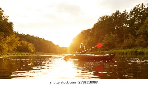 A solitary kayaker gracefully paddles through a peaceful river during a serene sunset, completely surrounded by the vibrant colors of autumn foliage that paint the landscape beautifully - Powered by Shutterstock