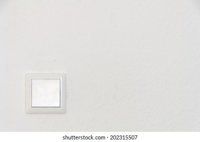 A Solitary Light Switch On A White Wall