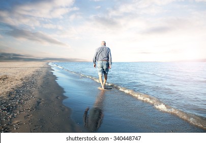 Solitary Old Man Walking On The Beach 