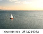 Solitary sailing boat on Lake Constance in Germany (Bodensee) sailing into the beautiful sunset