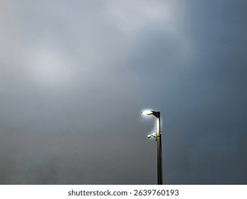 A solitary street lamp illuminates a dark. 