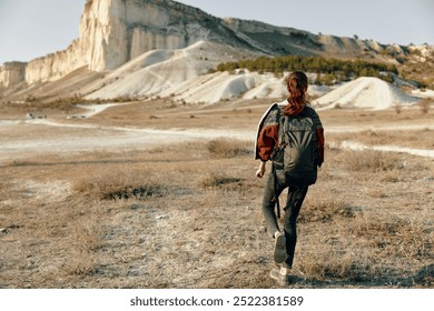 solitary traveler trekking through vast desert landscape with majestic mountain looming in the distance - Powered by Shutterstock