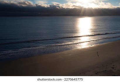 Solitary walker on the sand at Myrtle Beach as the sun rises - Powered by Shutterstock