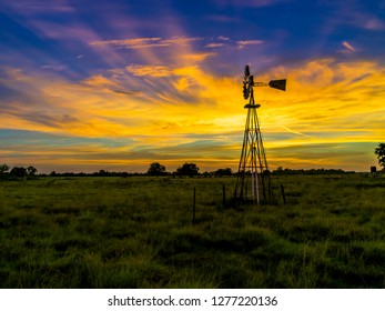 A Solitary Windmill On A Small Farm In Texas At Sunset