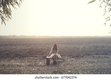 Solitary Woman Relaxes Sitting In The Middle Of Nature