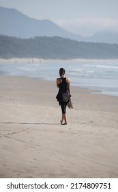 Solitary Woman Walks On The Beach