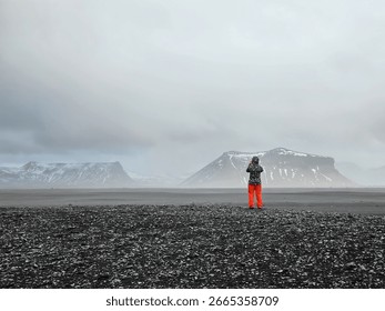 Solitude and exploration concept with a figure in a desolate volcanic landscape in Iceland