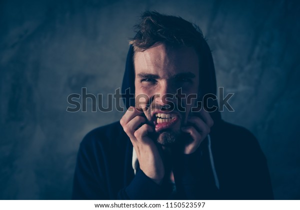 Solitude
loneliness side effect grin teeth people concept. Close up photo
portrait of terrifying scaring frightening with insane eyes hipster
biting nails isolated black gray
background