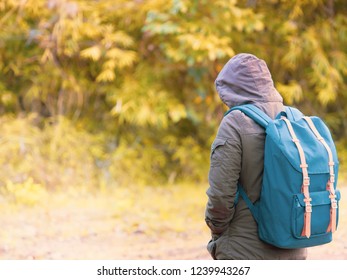 solo backpack and camping concept from backside of long hair woman in warm hoodie sweatshirt with her bag solo travel, relax, happy  and see to forest and mountain in morning after sunrise