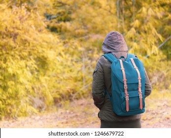 solo backpack and camping concept from backside of long hair woman in warm hoodie sweatshirt with her bag solo travel, relax, happy  and see to forest and mountain in morning after sunrise