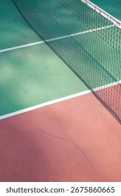 Solo, Central Java, Indonesia - January 31, 2024: Outdoor Tennis Court with Green Surface and Red Surroundings in Sunny Surroundings