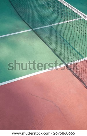 Solo, Central Java, Indonesia - January 31, 2024: Outdoor Tennis Court with Green Surface and Red Surroundings in Sunny Surroundings
