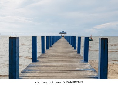 Solo, Central Java, Indonesia - June 10, 2026: Wooden Pier Leads to a Gazebo Over a Calm Ocean Horizon