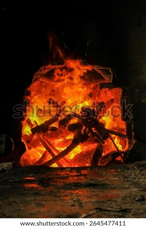 Solo, Central Java, Indonesia - June 16, 2025: Fire is blazing in the fireplace, intense heat, close -up from the bright orange fire of wood that burns wood