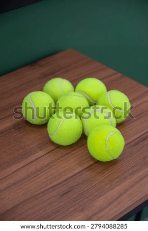 Solo, Central Java, Indonesia - June 6, 2026: Bright green tennis balls are stacked on a wooden table for sports practice and recreation.