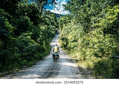 A solo cyclist on a dirt road cutting through a lush, green forest. The scenic, sunlit path ahead represents adventure, exploration, and the peaceful connection between nature and cycling.
 - Powered by Shutterstock