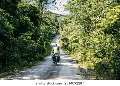 A solo cyclist on a dirt road cutting through a lush, green forest. The scenic, sunlit path ahead represents adventure, exploration, and the peaceful connection between nature and cycling.
 - Powered by Shutterstock