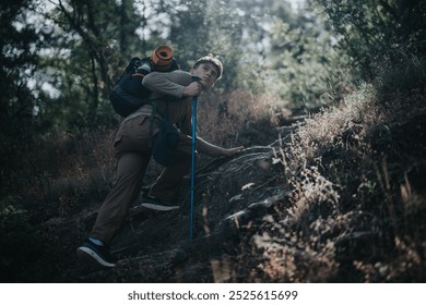 Solo hiker ascending a steep rocky trail in a dense forest. Adventurous outdoor activity and determination in nature. - Powered by Shutterstock