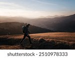 Solo Hiker Walking at Sunset on Mountain Ridge