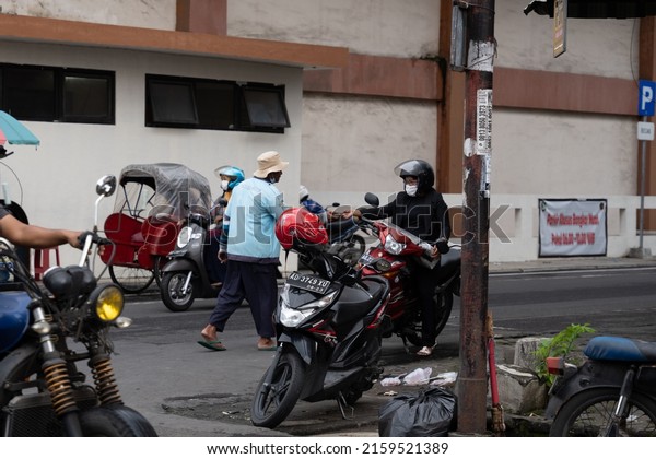 Solo,\
Indonesia - February 27, 2022: A Parking attendant receive a money\
from a woman at Pasar Klewer in Solo (Central\
Java)