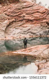 Solo Male Traveller Working Holiday Visa In Black Clothes In The Spectacular Hamersley Gorge In Karijini National Park. It's One Of The Hidden Gems Of Australia And A Must Do For Backpackers.